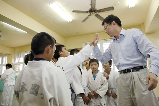 Minister Chiang visits Zhiben Primary School in Taitung County and claps hands with the Judo players