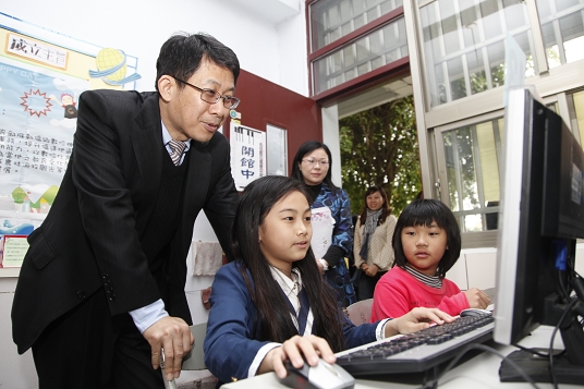 Minister Chiang talks with the students that are using the Internet to search for the learning material