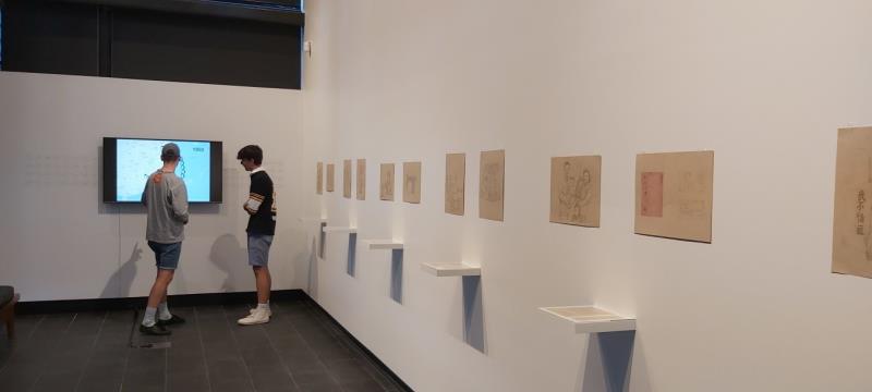 Viewers exploring details of the multi-media Drawing Near exhibition at the Australian National University